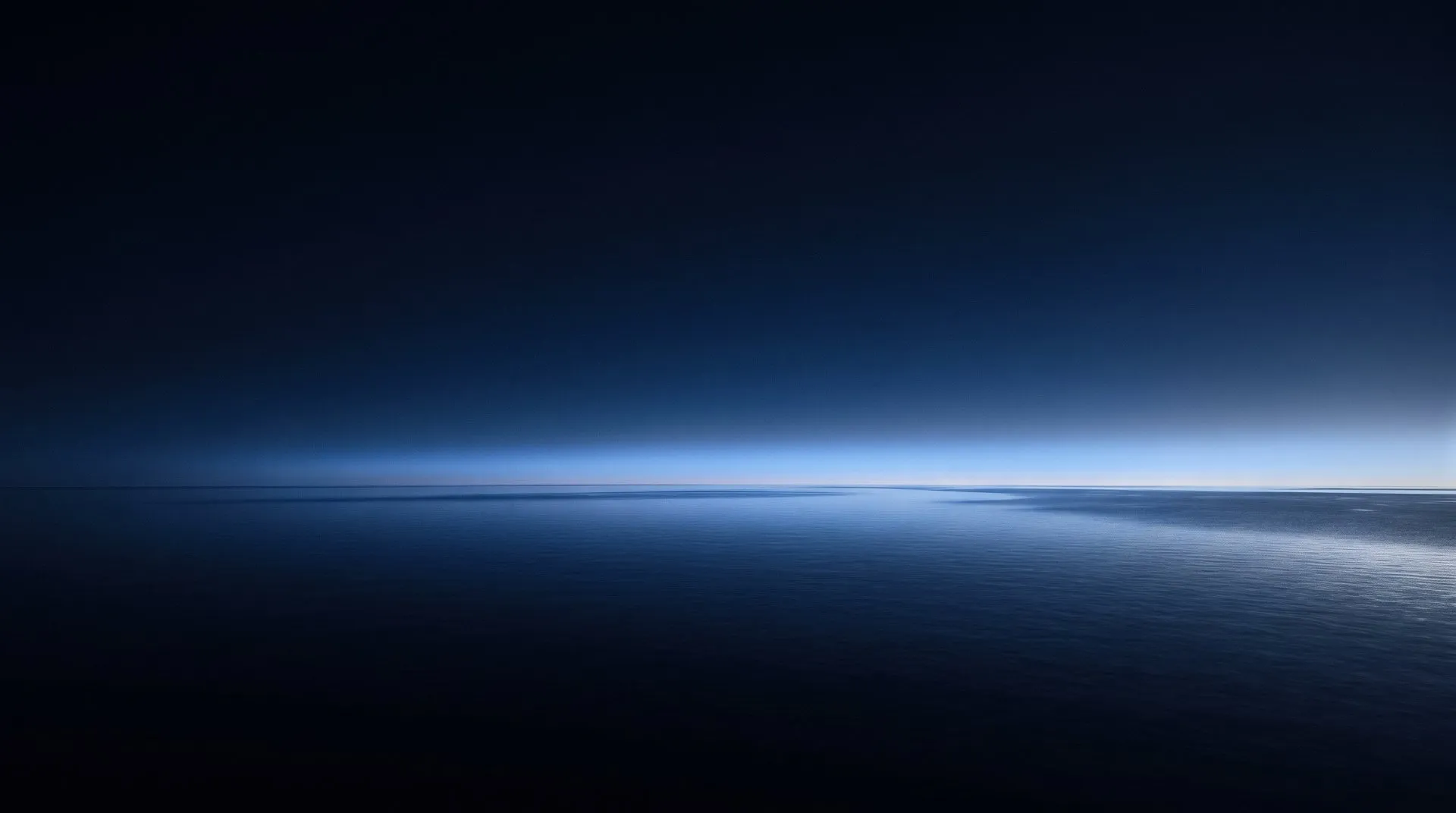 First light over a calm open sea just before dawn